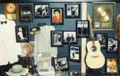 a photo of guitars, records, framed photos, and other pop music memorabilia