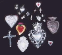 a photo of several milagros, many are heart shaped